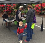 color photo of woman with small children examining package of microgreens